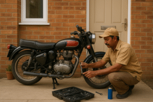 Indian mechanic servicing a classic black and red motorcycle at a doorstep with tools arranged nearby.